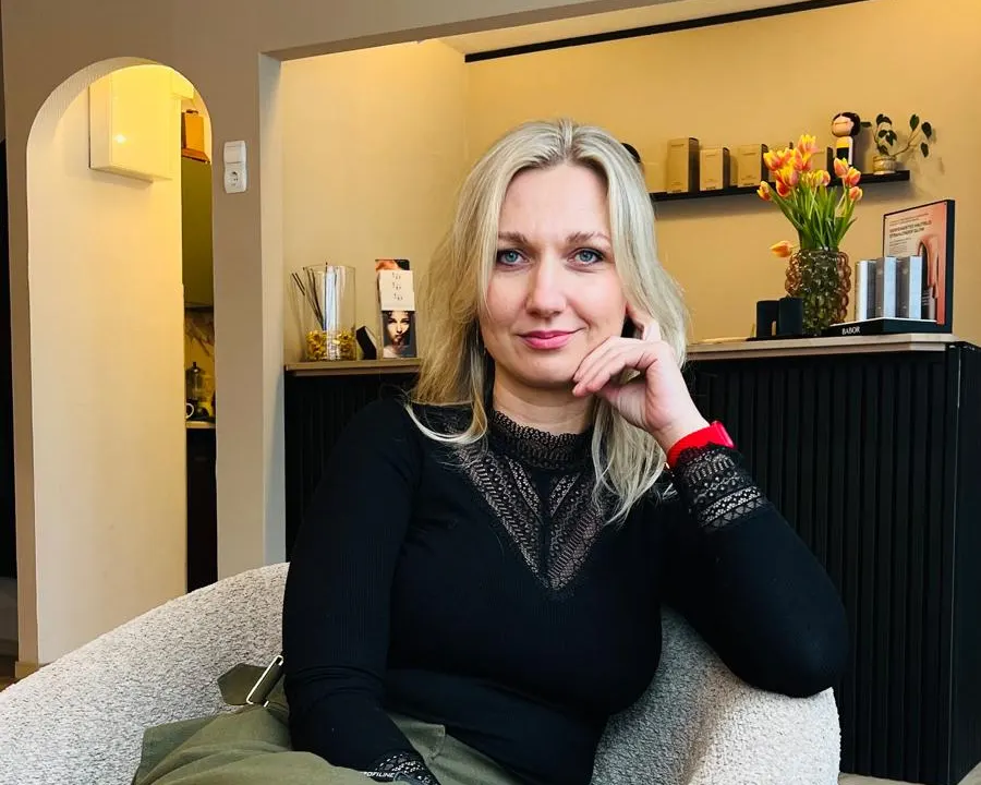 Lucia sitzt im Sessel vor dem Empfang, dahinter Tulpen auf dem Tresen